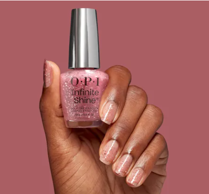 hand with nails done in OPI nail polish pink glitter 