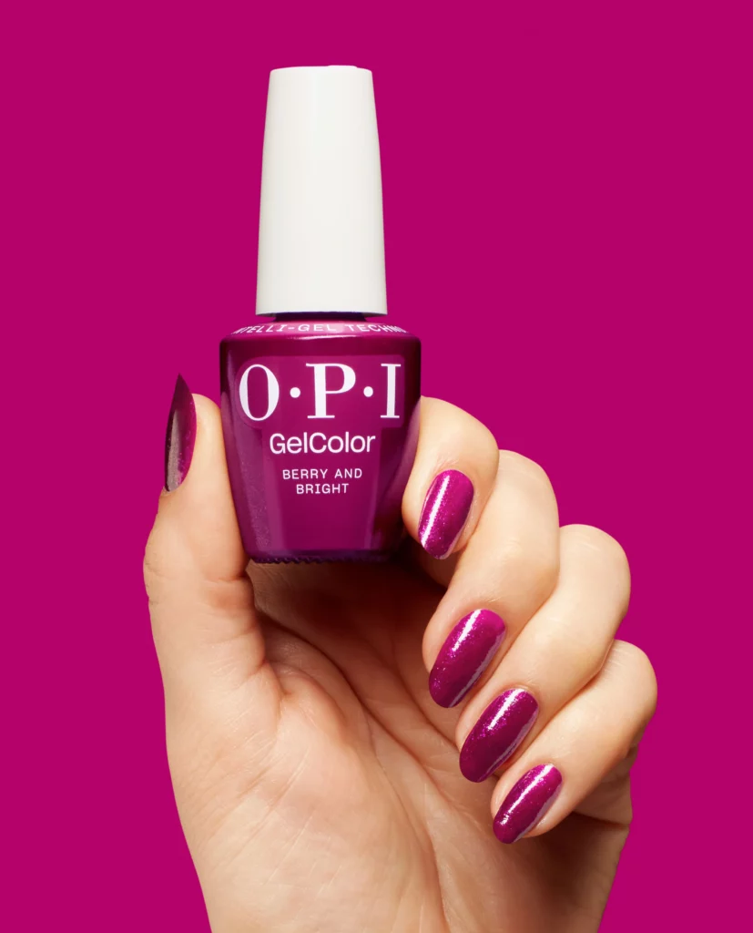 hond holding OPI nail polish and nails done in color Berry and Bright 