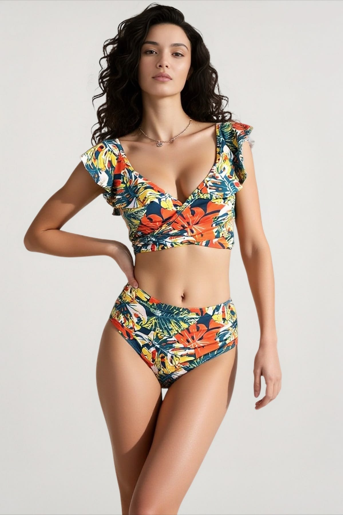Woman posing in a colorful tropical-floral bikini set with a wrap-style top and high-waisted bottoms, against a neutral background.