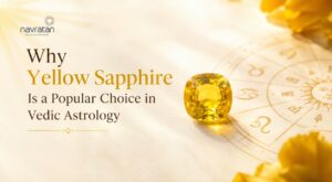 Yellow sapphire gem rests on a zodiac wheel against a warm, golden background, introducing why it's popular in Vedic astrology (Navratan).