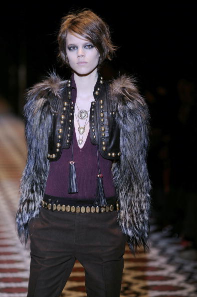 The Gucci Fall/Winter 2008/2009 ready-to-wear runway collection featured a cropped faux-fur bolero jacket with gold studs on the front.