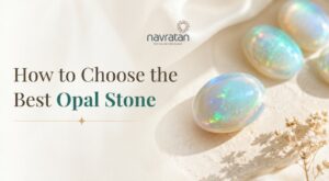 Banner announcing a guide on choosing the best opal stone, with opal gems on sand and Navratan logo.