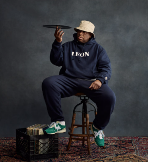 man wearing Aime Leon Dore hoodie while spinning record on finger