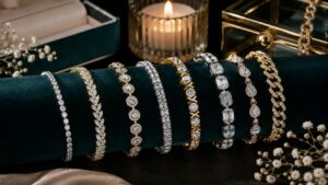 Row of diamond and gemstone bracelets on dark green velvet display with a lit candle behind.
