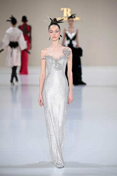 The Tamara Ralph Haute Couture Spring/Summer 2026 “La Lumière Dorée” collection showcased a fine silver-crystal mesh gown adorned with a sculptural crystal peacock-feather neckline