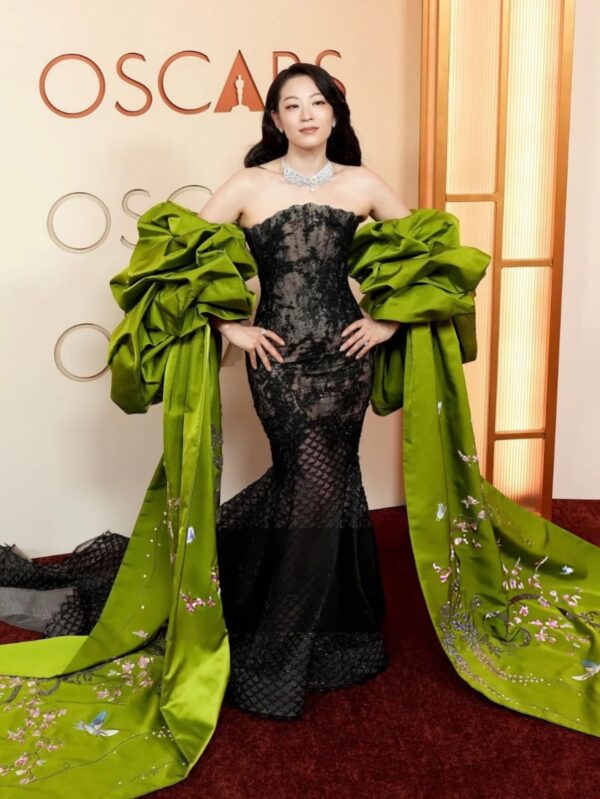 Arden Cho attended the 98th Academy Awards wearing a Miss Sohee Haute Couture metallic floral Chantilly lace mermaid gown, complemented by an embroidered silk stole that extended into trailing trains and a Messika “Firebird” necklace.