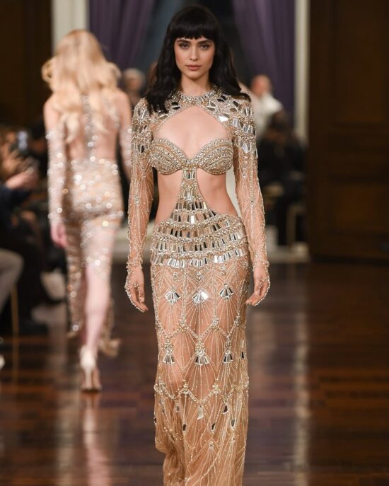 Idan Cohen’s (House of Idan) Spring/Summer 2025 Bridal collection featured an embellished gown with a keyhole cutout sweeping across the upper chest, along with another cutout extending from the midriff through the waist and sides