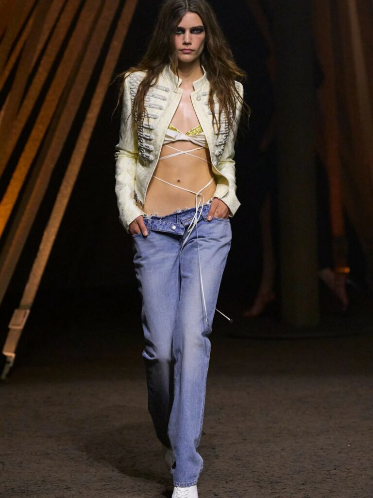 Seán McGirr’s Alexander McQueen Spring/Summer 2026 ready-to-wear collection featured a cropped mandarin-collar jacket embellished with intricate white braided frogging—hussar-inspired embroidery with loop fastenings—running along both front panels