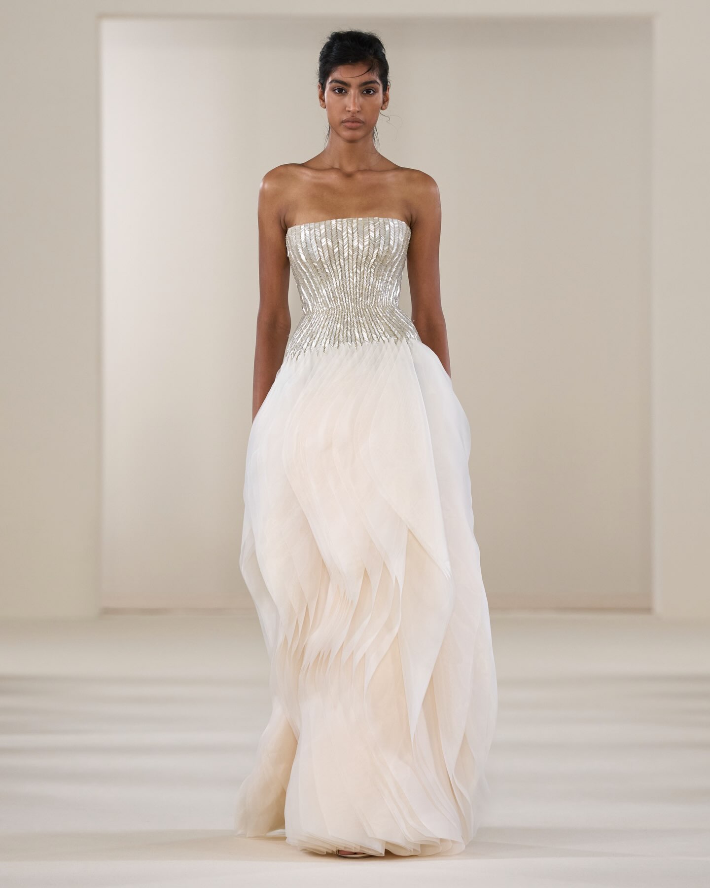 Rami Al Ali’s Fall/Winter 2026/2027 Haute Couture collection, “Threads of Light: A New Dawn,” presented an off-the-shoulder ball gown featuring a structured, beaded bodice and a floor-length silk organza skirt