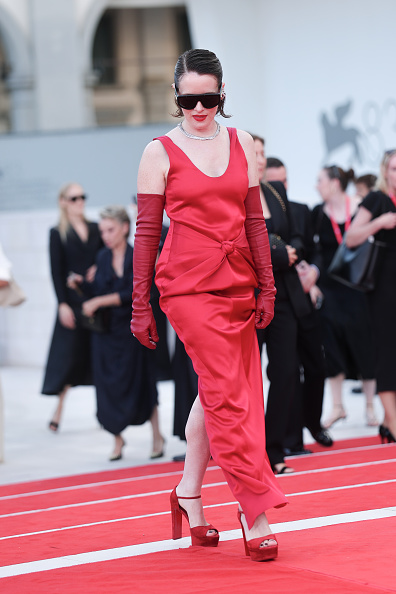 Claire Foy walked the red carpet at Sala Grande for the premiere of “Ink” at the 83rd Venice International Film Festival, wearing a custom sleeveless Bottega Veneta gown paired with matching evening gloves, Christian Louboutin “Sandaloo” platform sandals, Bottega Veneta Knot aviator sunglasses, and Swarovski jewelry.