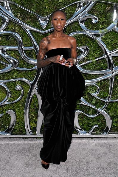Cynthia Erivo arrived at the Lucas Museum of Narrative Art Opening Night Gala in a black Khaite “Bronte” off-the-shoulder pleated bubble dress, styling the look with matching Christian Louboutin “So Kate” suede pumps and David Webb jewelry.