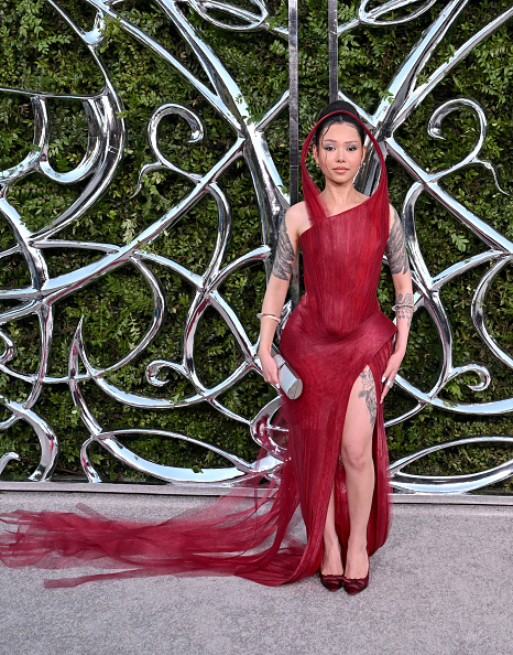 Bella Poarch attended the Lucas Museum of Narrative Art Opening Night Gala in a deep crimson and burgundy Do Long mesh gown, drawing inspiration from ancient red coral reefs and distinguished by its sculptural stand-up collar and thigh-high slit.