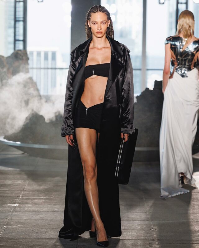 Fashion model Jordan Rand walked Grace Ling’s Spring/Summer “Neanderthal” runway in the black “Claw” three-piece set—a trench coat, bralette, and mini shorts