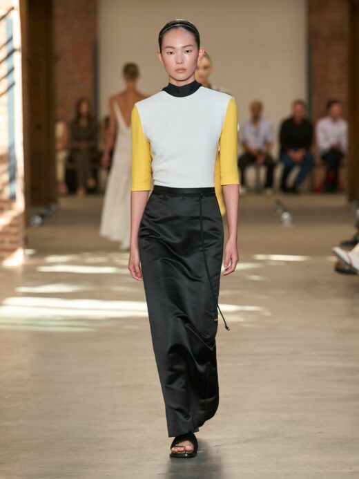 South Korean model Yun Seo Woo appeared in Calvin Klein’s Spring/Summer 2027 ready-to-wear show at New York Fashion Week, dressed in a three-tone ensemble consisting of a mid-length-sleeve jersey top and a high-waisted, floor-length satin maxi skirt, accented by a back slit and a slender side-tie cord cascading toward the ankles