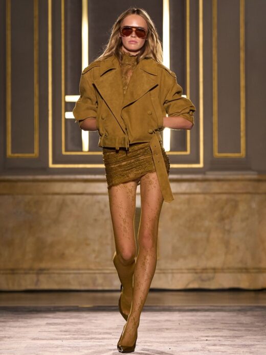 Retrofête’s “La Société d’Opulence” Fall/Winter 2026 collection featured a Rubee ochre cropped suede trench coat paired with matching sheer tights