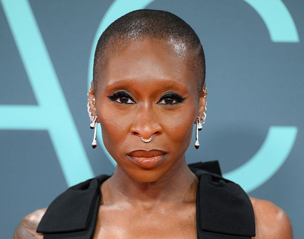 A closer look at Cynthia Erivo at the “Prima Facie” premiere gala during the 2026 BFI London Film Festival shows her wearing a custom Prada silk-satin bias-cut gown adorned with grosgrain bows, paired with Marli Cleo diamond drop earrings set in 18-karat white gold.