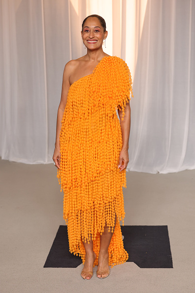 Tracee Ellis Ross graced the 2026 Academy Museum Gala in a tangerine-orange Balenciaga high-low dress with a one-shoulder silhouette, pairing the look with transparent sandals and A.Jaffe long-drop earrings.