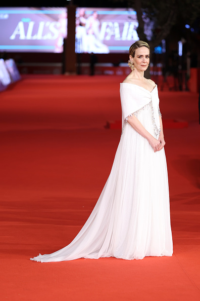 Sarah Paulson wore a bespoke white Miu Miu off-the-shoulder gown, complemented by cape-like fabric wrapped around her shoulders and arms.