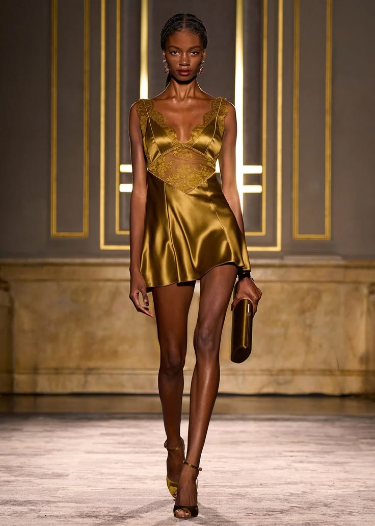 Retrofête’s Fall/Winter 2026 “La Société d’Opulence” ready-to-wear runway collection featured a Bonny ochre V-neck A-line mini dress trimmed with sheer Chantilly lace.
