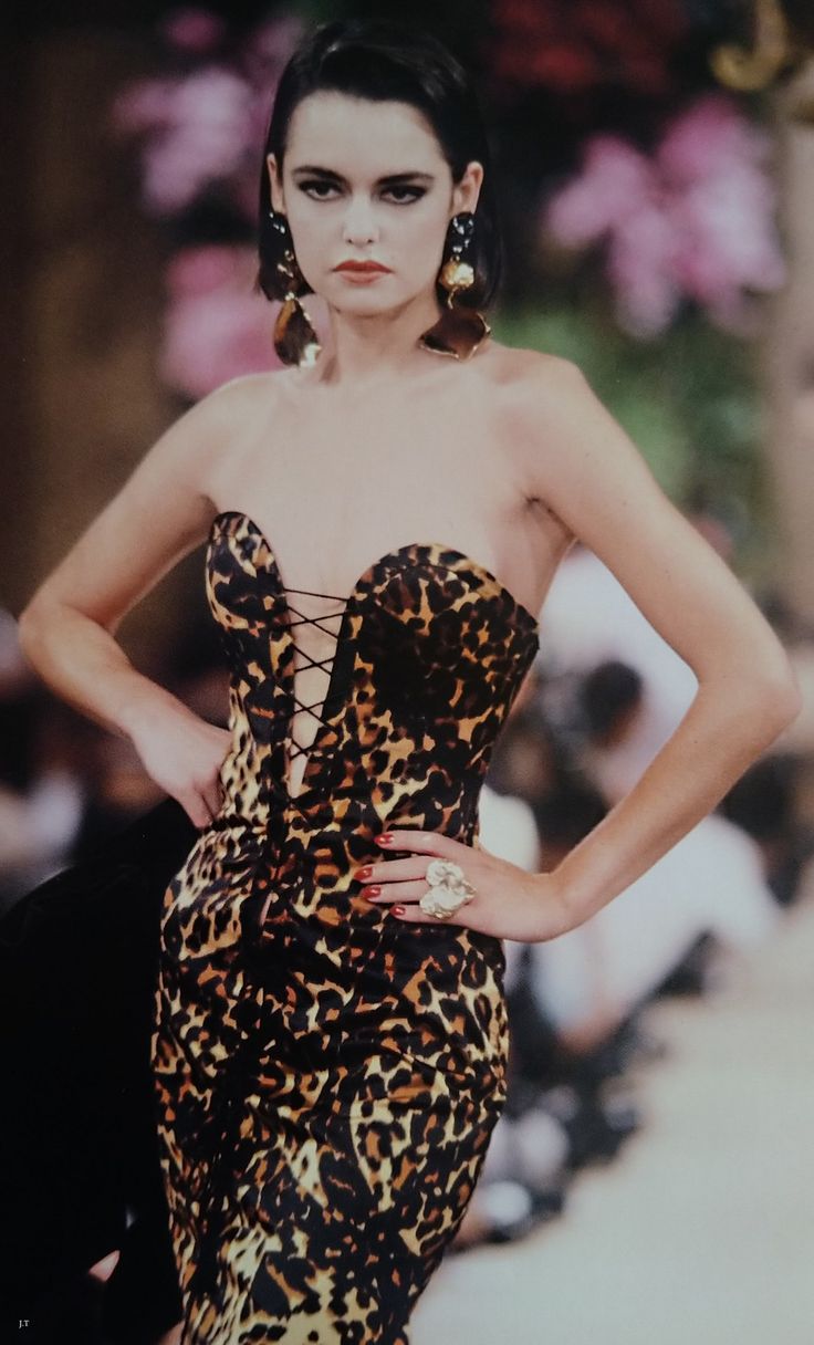 Yves Saint Laurent’s Haute Couture Fall/Winter 1986–1987 “Golden Tigress” collection included a strapless leopard-print velvet mermaid gown, designed with a corset-like sweetheart bodice and built-in bra cups, secured by black silk cords that created lace-up detailing across the front and continued around the back.